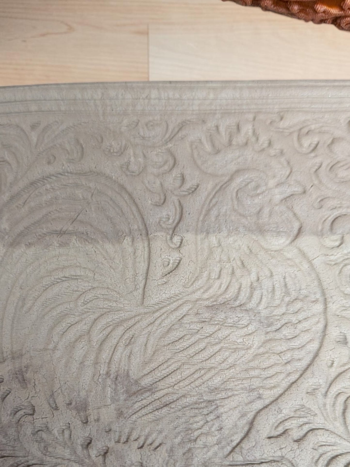 Rooster texture roller pressed into clay showing rooster pattern